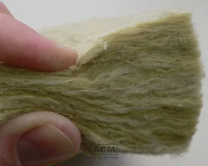 Close-up of mineral wool insulation held by hand, showing fibrous texture
